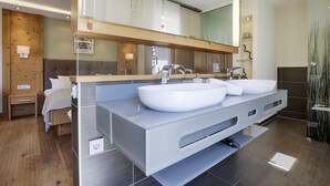 Ein modernes Badezimmer mit einem großzügigen Waschtisch, zwei Waschbecken und einem Spiegel darüber.