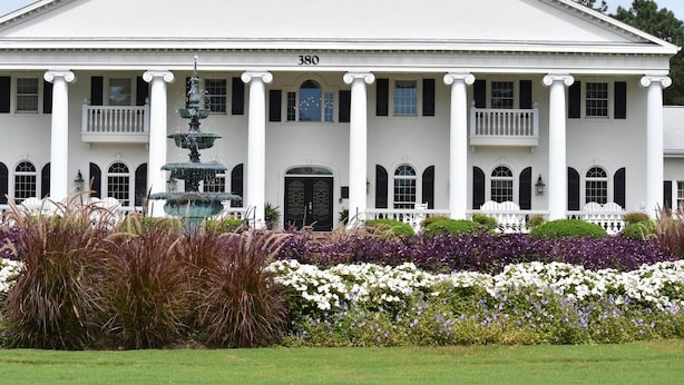 A large white building with a symmetrical facade, columns, and a central entrance.