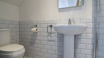 Ein Badezimmer mit Toilette, Waschbecken und einem beleuchteten Spiegel.