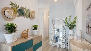 Ein modernes Badezimmer mit einem Holzwaschtisch, einem Spiegel mit aufwendigem Rahmen und Topfpflanzen.