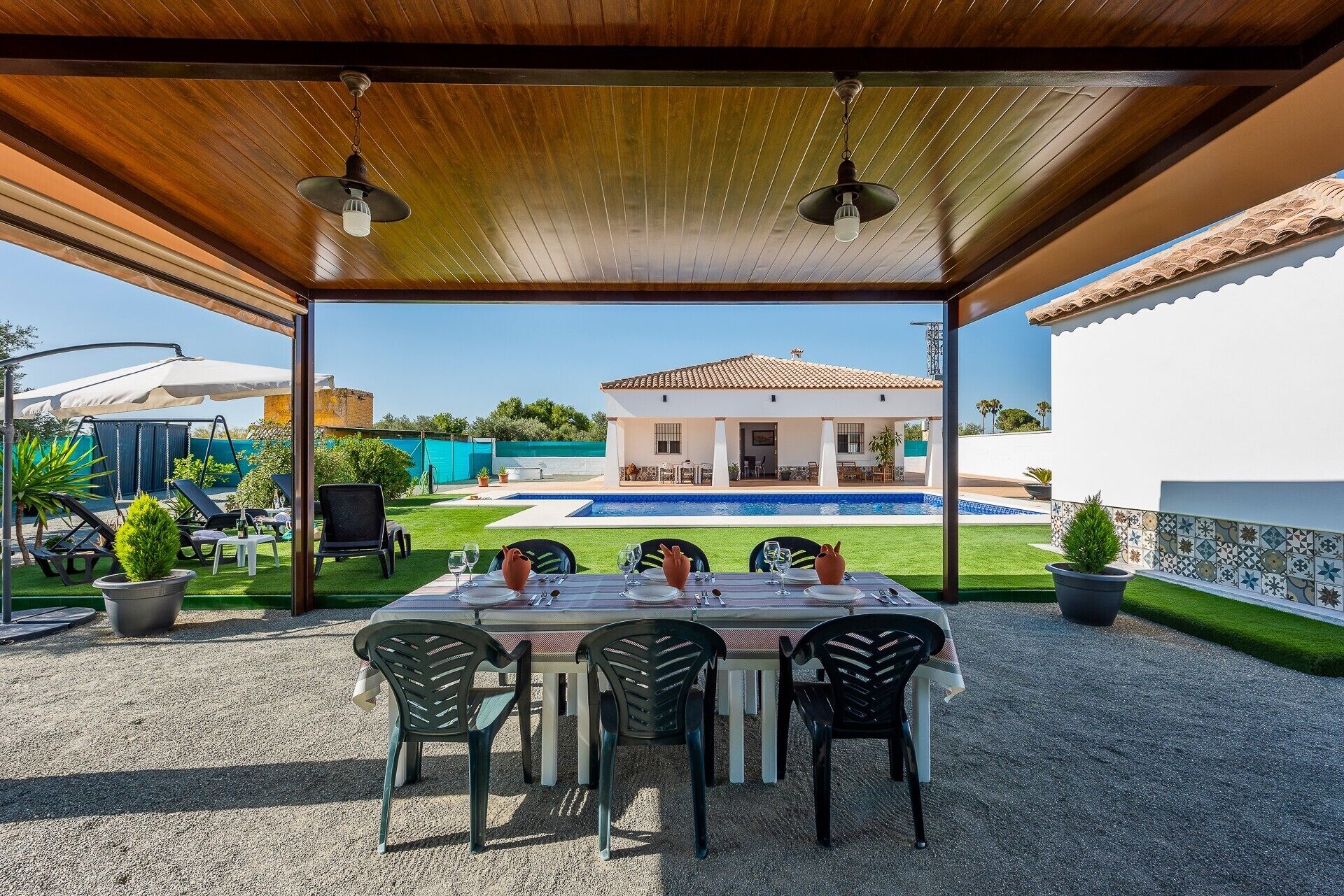 Eine Außenpatio mit einem Essbereich, einem Schwimmbad und einem Haus im Hintergrund.