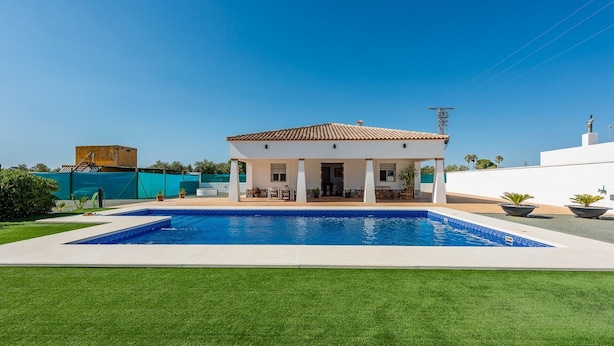 A house with a swimming pool, a patio, and a view of the sea. - Villa "Casa Brisa del Valle" with Private Pool, Covered Terrace & Wi-Fi (Sevilla)