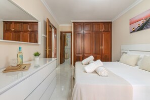 Ein Hotelzimmer mit einem großen Bett, einem Schminktisch mit Spiegel, einem Holzschrank und einem Bild an der Wand.