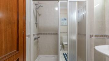 Un baño con ducha, inodoro y lavamanos.