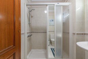 A bathroom with a shower, toilet, and sink.