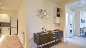 A modern kitchen with a refrigerator, microwave, and a herringbone-patterned floor. - Bahari (Lyme Regis)