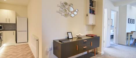 A modern kitchen with a refrigerator, microwave, and a herringbone-patterned floor.
