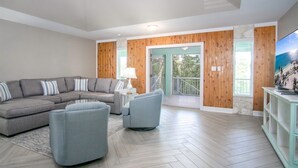 A living room with a sectional sofa, two armchairs, a small table, and a TV on a stand. - Pozitively Bliss updated 3bed/2bath single family home near Sombrero Beach with private pool & dockage (Marathon)