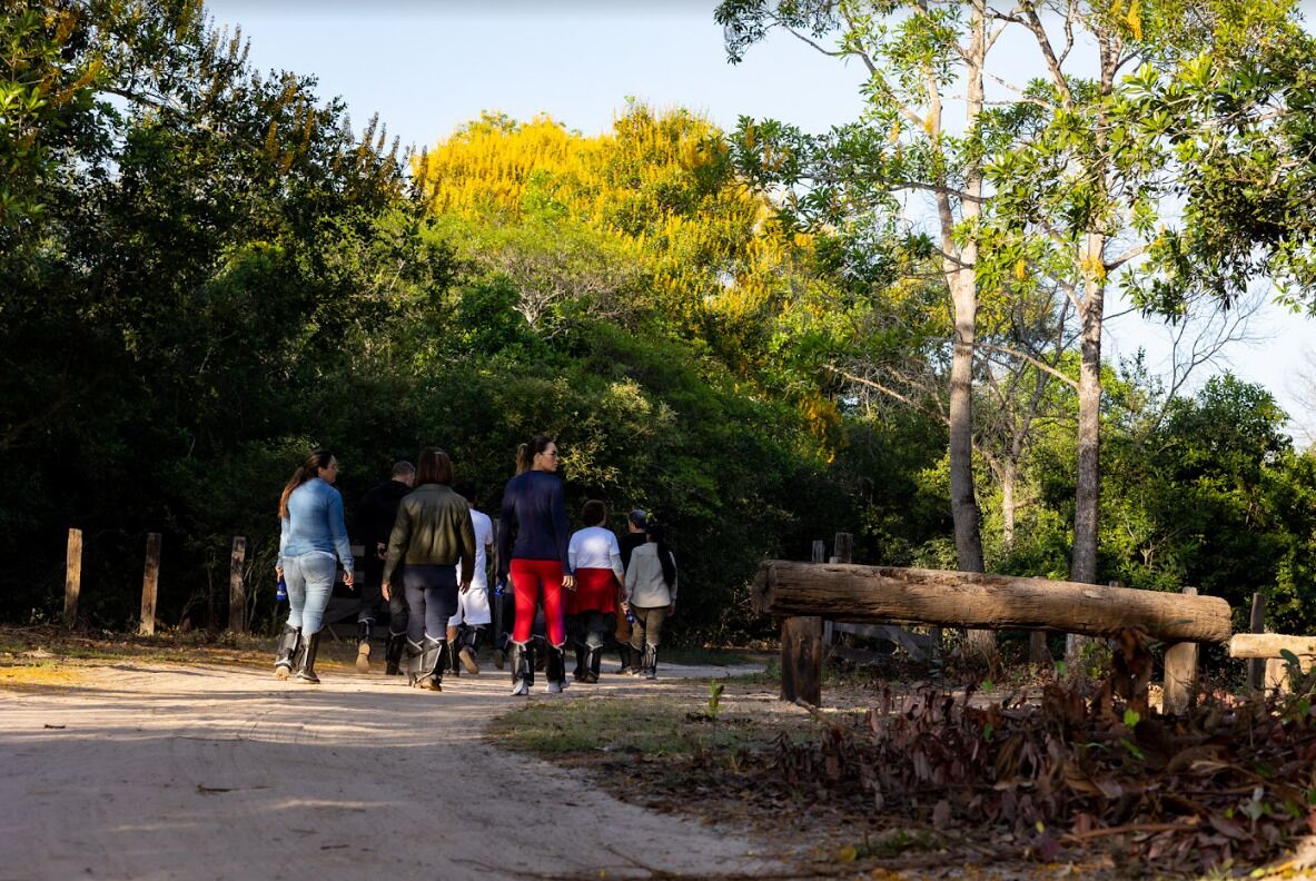 Un grupo de personas caminando por un sendero de tierra en un área boscosa.