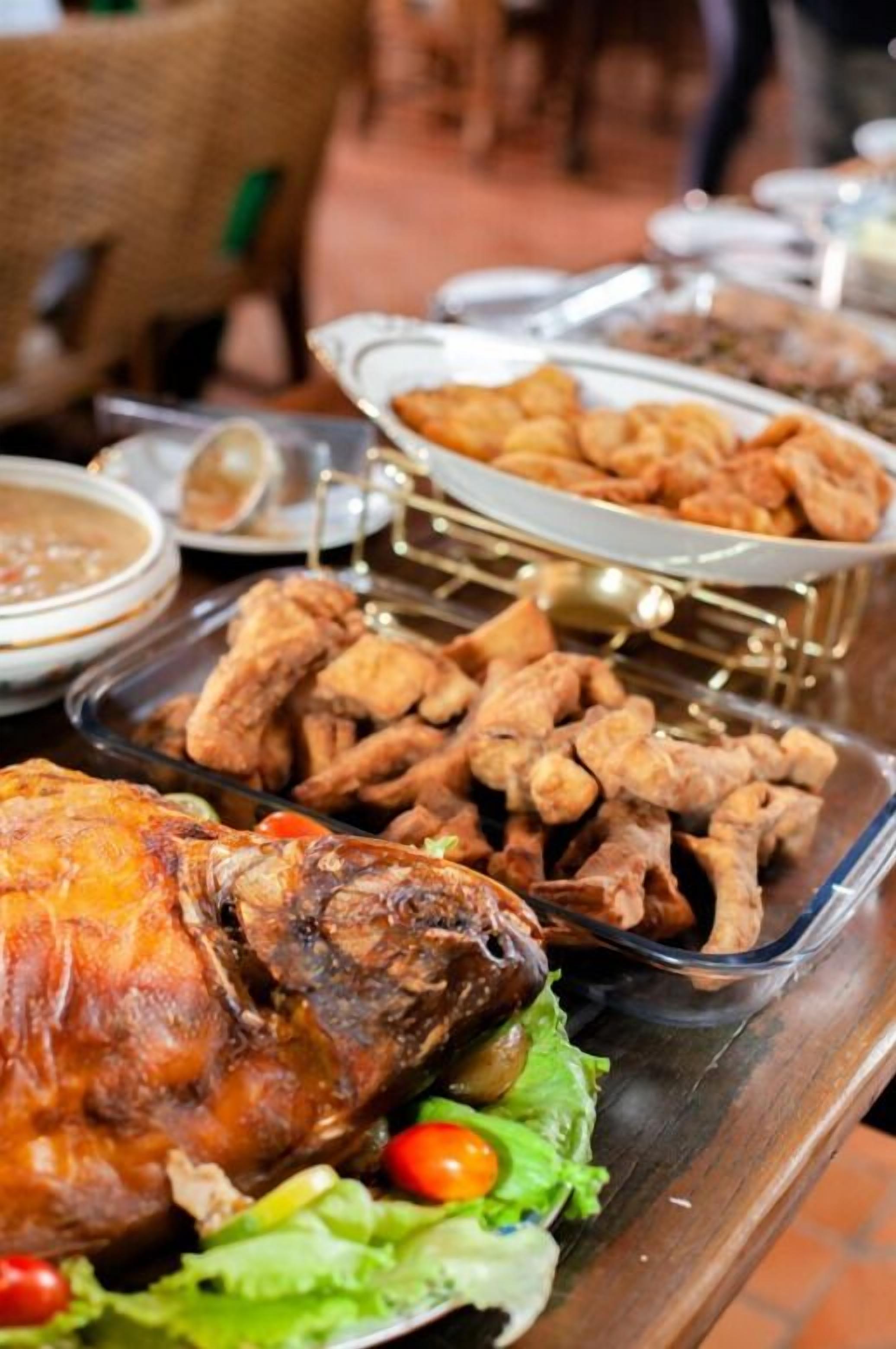 A buffet table with a roasted chicken centerpiece, various side dishes, and a salad.