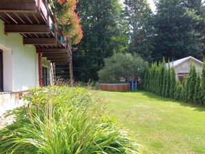 Il s’agit d’une propriété résidentielle dotée d’un porche abrité, d’une pelouse bien entretenue et d’une rangée d’arbres à feuilles persistantes.