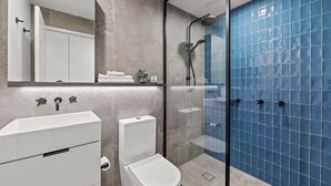 A modern bathroom with a glass-enclosed shower, a white sink, and a toilet. - Fortitude Valley Apartments By Cllix (Brisbane)