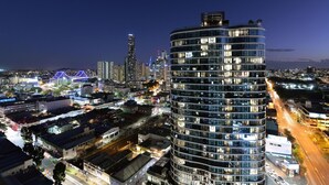 A modern high-rise building with multiple floors, surrounded by a cityscape at night. - Fortitude Valley Apartments By Cllix (Brisbane)