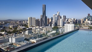 Ein Hochhaus mit Schwimmbad und Blick auf die Stadtlandschaft.