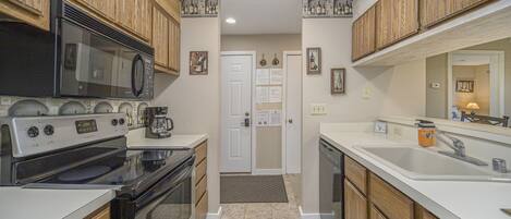 Kitchen features a central island, stainless steel microwave, oven, and modern sink.