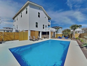 A two-story house with a swimming pool, wooden deck, and a fenced backyard. - Shore Beats Work | Stunning Ocean Views, Private Pool (Tybee Island)