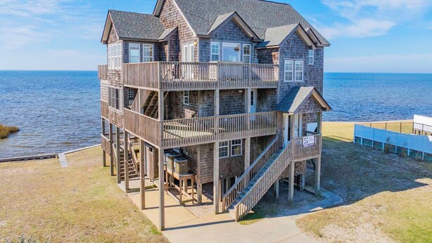 A multi-story wooden house with balconies, located near a beach. - Soundfront Home with Private Pool, Hot Tub, and Private Windsurfing Access (Waves)