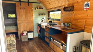 Una cocina compacta con armarios de madera, un lavamanos y una estufa.