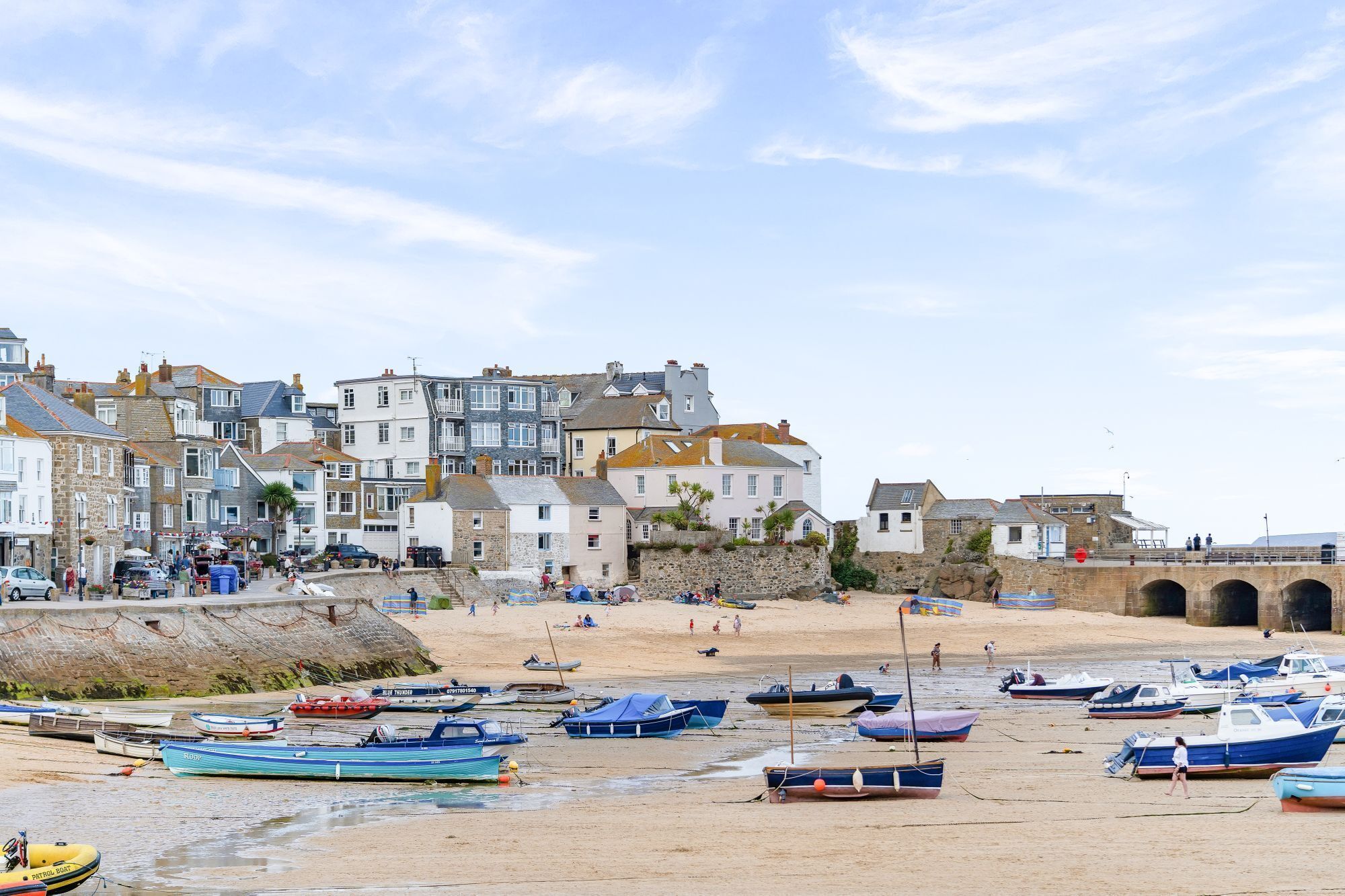A coastal town with historic buildings, a sandy beach, and boats.