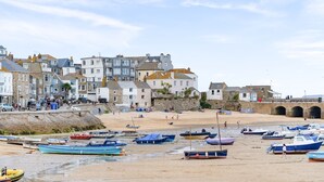 Une ville côtière dotée de bâtiments historiques, d’une plage de sable et de bateaux.