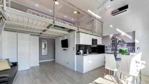 A modern apartment with a kitchen, dining area, and a living room.