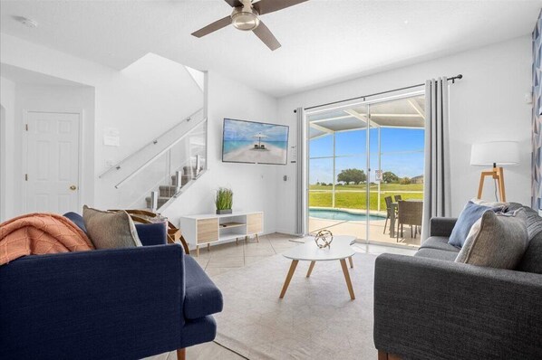 Relax in this stylish living room with a sliding door leading to a poolside view.