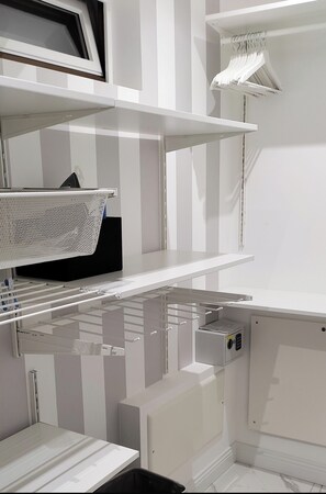 Kitchenette with microwave, refrigerator, and sink, offering ample storage for kitchenware and utensils.