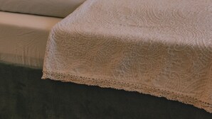 A neatly made bed with a patterned bedspread and pillows, a headboard, and a bedside lamp. - 164 apt. - Spacious & exclusive appartment with view (Pfitsch)
