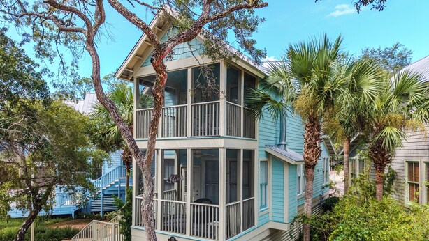 A two-story building with a balcony, surrounded by trees and vegetation. - Mermaid's Rest Steinhatchee Landing Resort - Sleeps 6 (Steinhatchee)