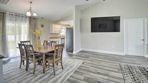 A dining area with a wooden table and chairs, a ceiling fan, and a kitchen in the background. - 3 Mi to Golf: Loris Home w/ Big Private Yard! (Loris)