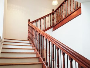 A wooden staircase with a handrail and a light fixture above. - Liquorstane - UK40568 (Falkland)
