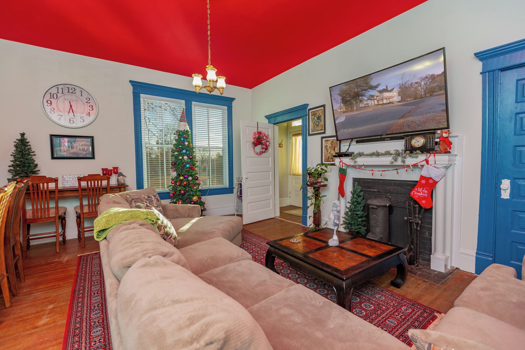 A cozy living room with a large beige sofa, a wooden coffee table, and a fireplace with a Christmas stocking.