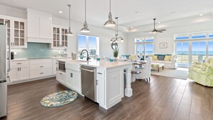 A spacious kitchen with white cabinetry, a central island, and pendant lighting. - Seas the Day-Gulf View Private Pool Home Across the Street from the Beach (Navarre)