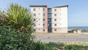 A multi-story hotel with a central vertical structure, balconies, and a view of the sea. - 2 bedroom accommodation in Newquay (Newquay)
