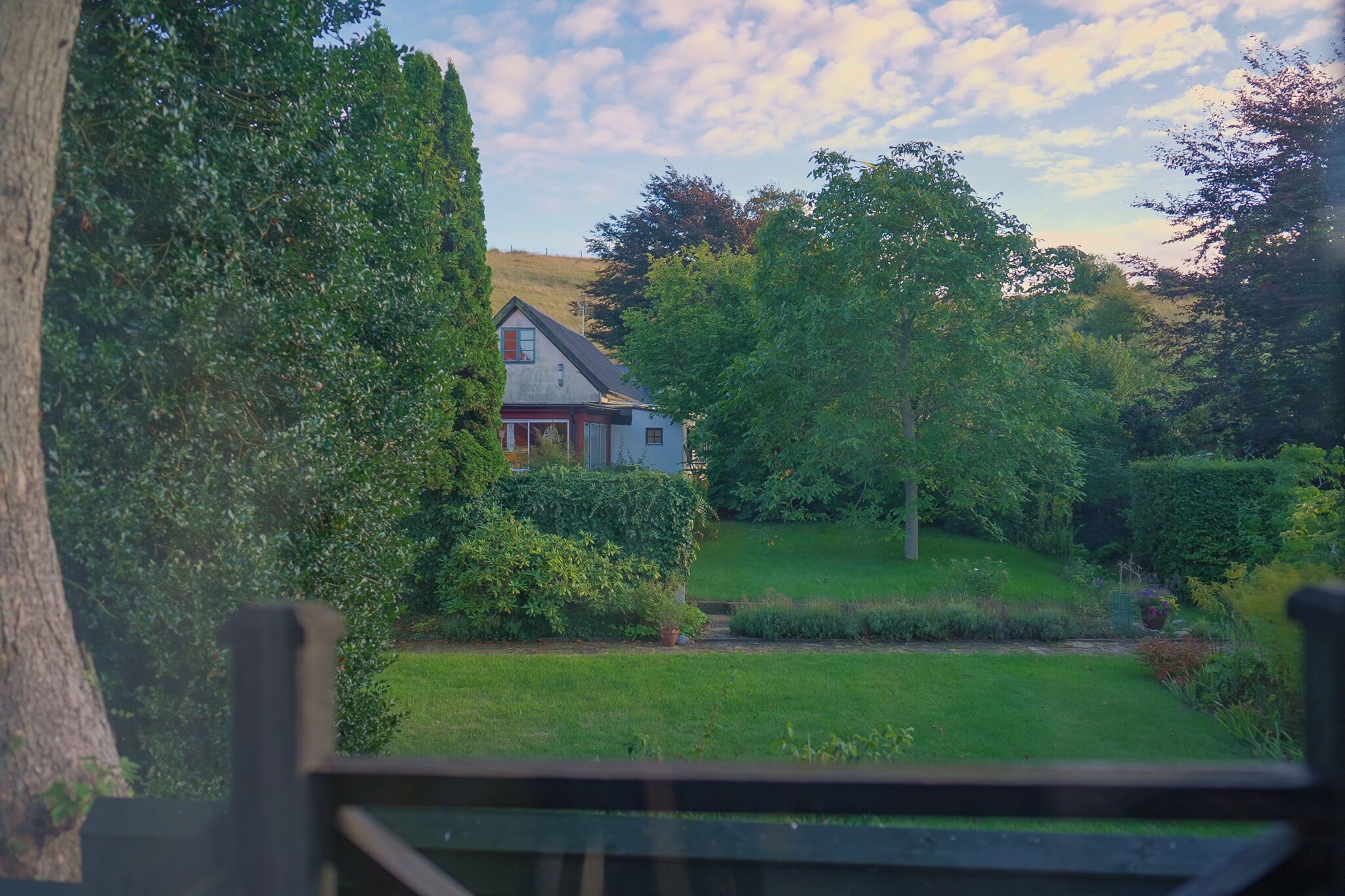 Ein Haus, umgeben von üppiger Vegetation und einem gepflegten Garten.