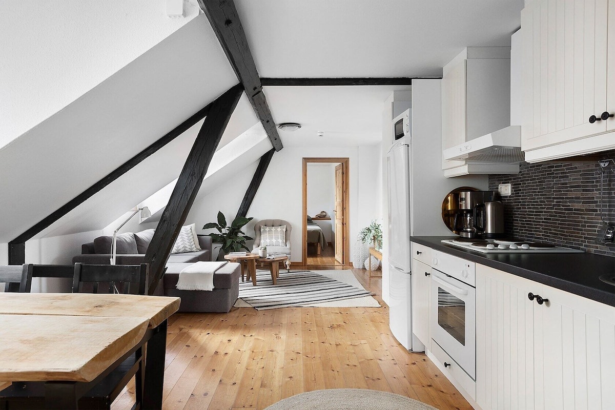 A loft-style apartment with a kitchen, dining area, and living space.