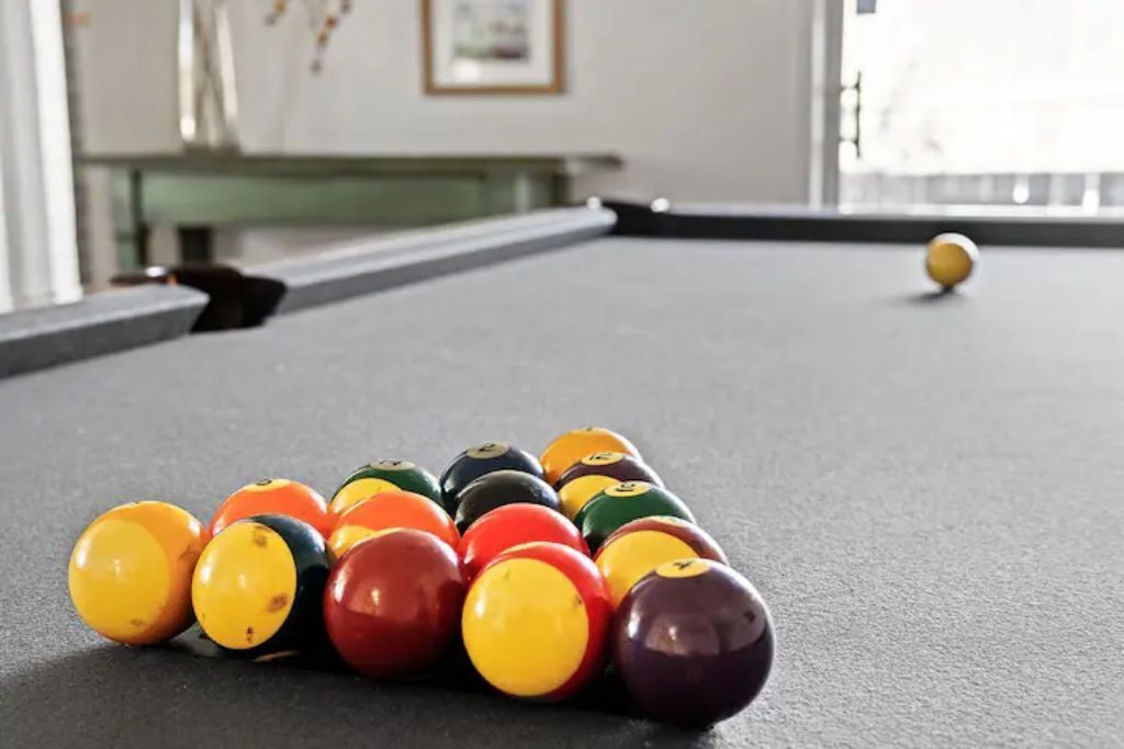 Uma mesa de bilhar com bolas coloridas dispostas em triângulo.