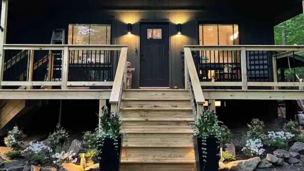 A cabin with a wooden deck, a front door, and two windows. - Saturdays Cabin, Hot Tub, Hammock, Gas Firepit (pocono lake)
