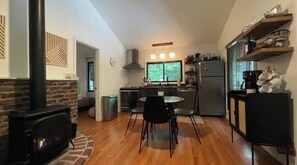 A modern kitchen with a central island, a dining area with chairs, and a fireplace. - Saturdays Cabin, Hot Tub, Hammock, Gas Firepit (pocono lake)