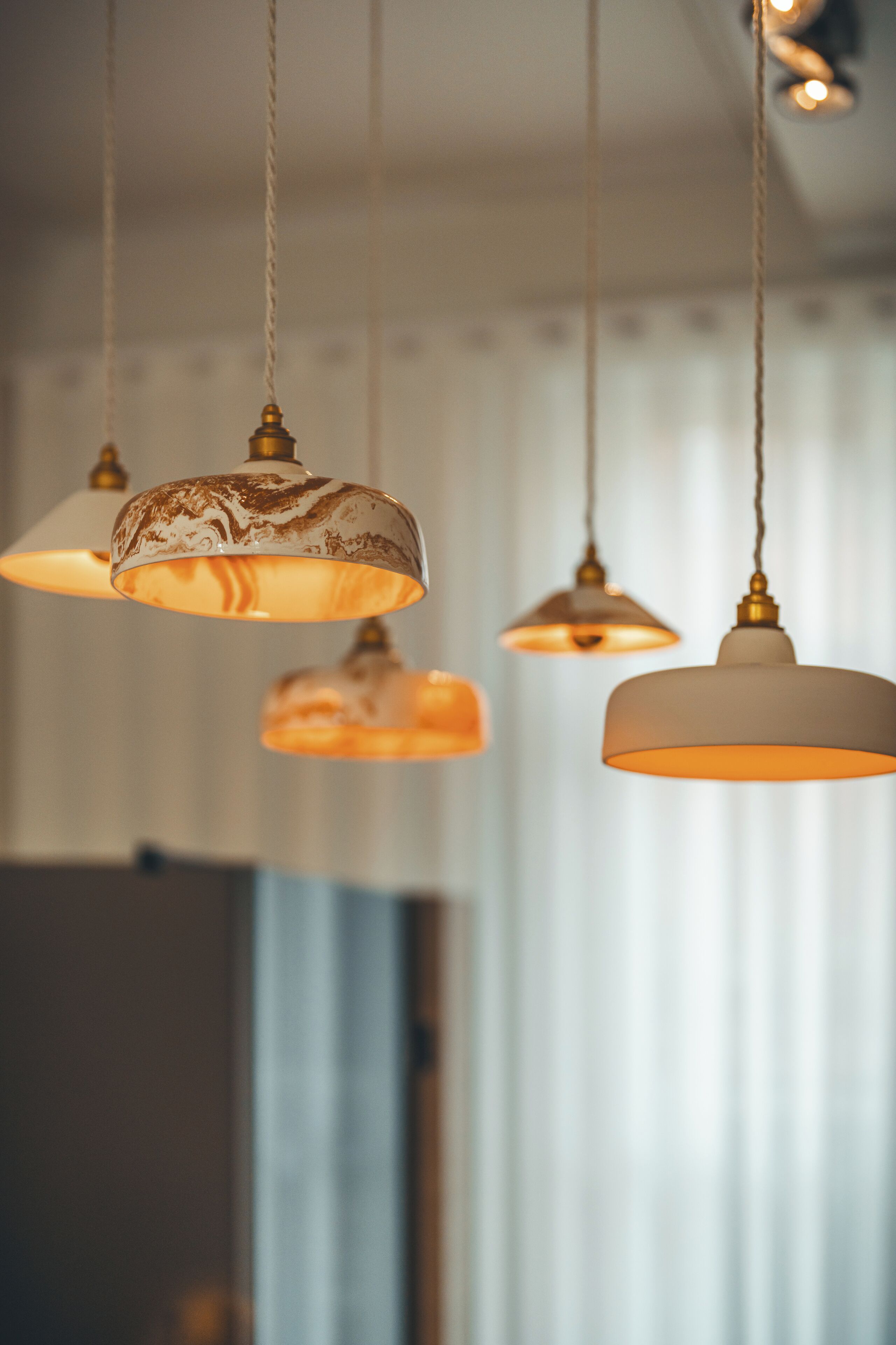 A series of pendant lights with a classic design, hanging from the ceiling in a well-lit room.