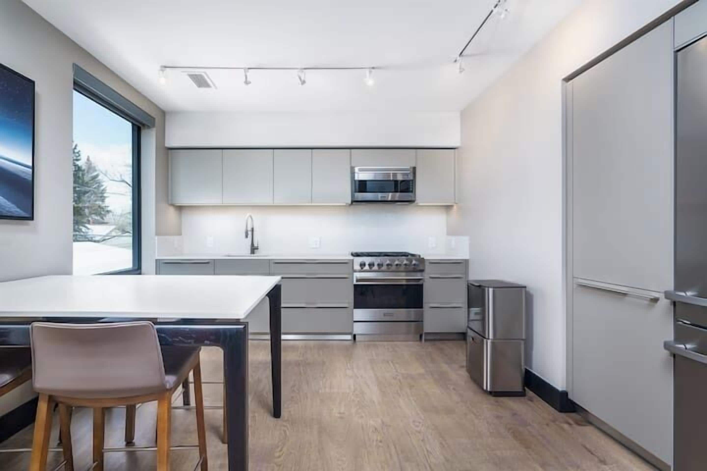A modern kitchen with a stainless steel refrigerator, oven, and microwave.