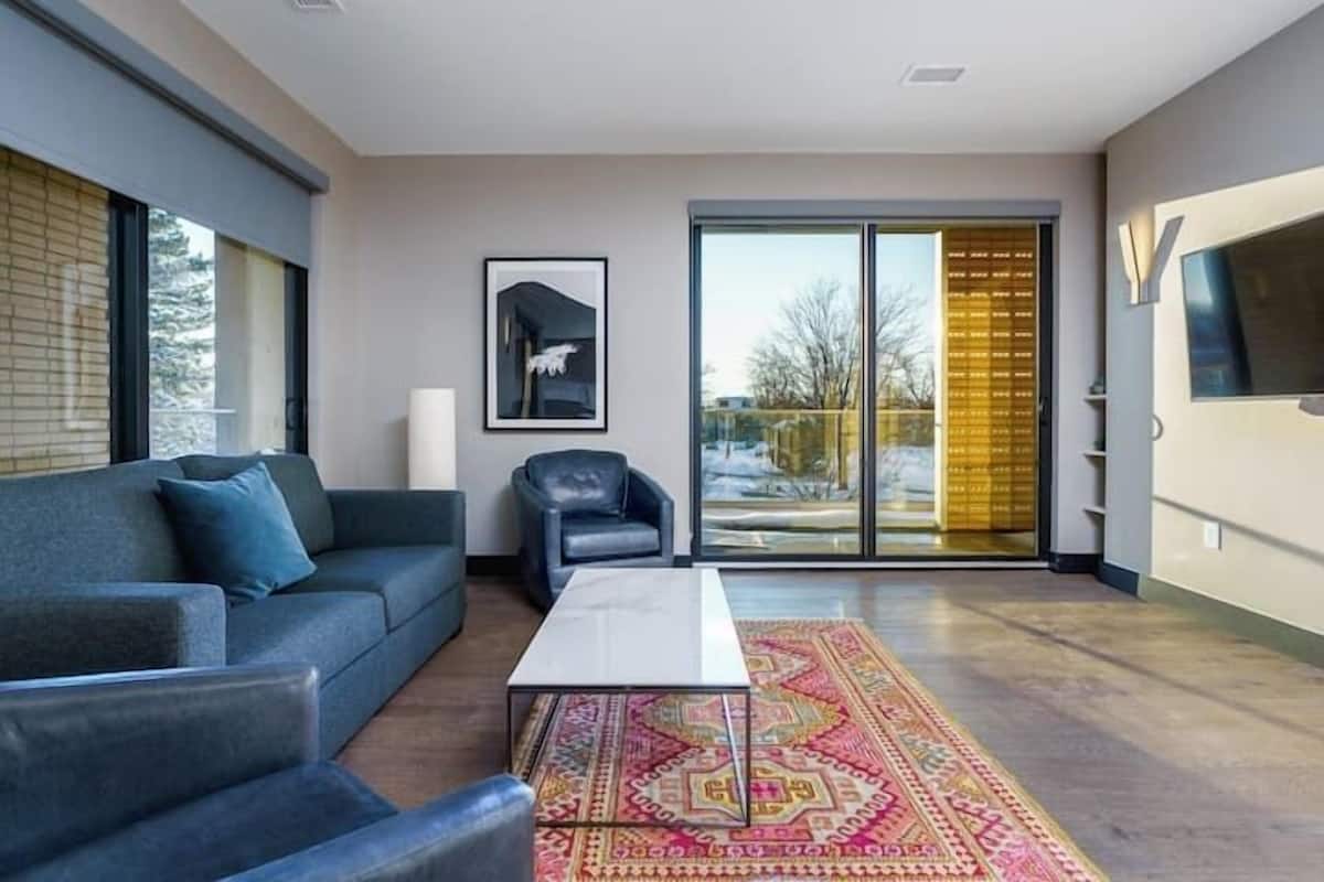 Uma sala de estar moderna com sofá, poltrona e mesa de centro.