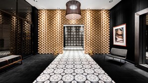 Un vestíbulo moderno con piso estampado, un banco central y un diseño de pared único.