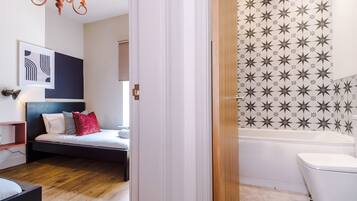 Design huis | Badkamer | Een bad/douchecombinatie, een haardroger, handdoeken