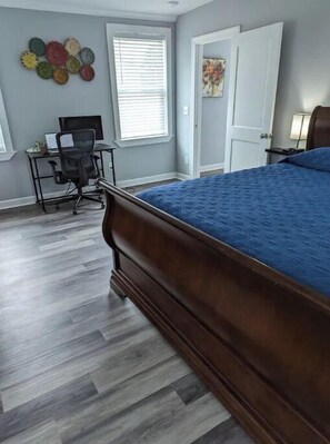 Relax in a spacious room with a large bed, desk, and comfortable chair.