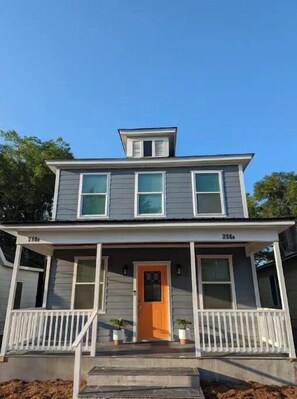 Two-story home with a charming front porch and gabled roof.