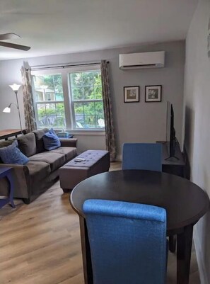 Relax in this inviting living room with a round table, comfortable sofa, and flat-screen TV.