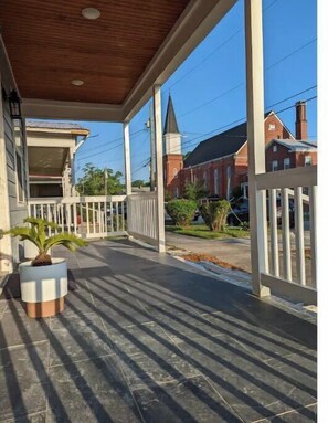 Relax on the covered porch surrounded by lush greenery and take in the views of the historic buildings.