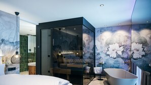 Een moderne slaapkamer met een in glas gesloten inloopkast, een groot bed, een vrijstaand bad en een muurschildering.