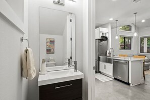 Een bad/douchecombinatie, een haardroger, handdoeken, zeep